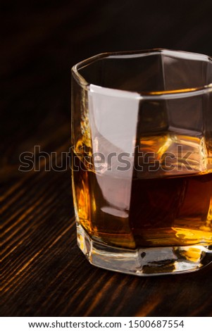 Glass of whiskey served on wooden planks.