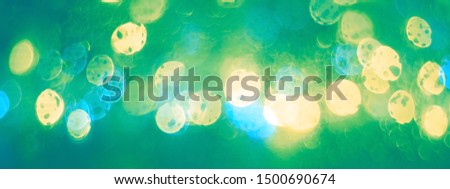 Abstract yellow green bokeh lights background, border. Blurred colored lights garlands. Beautiful Christmas and New Year background