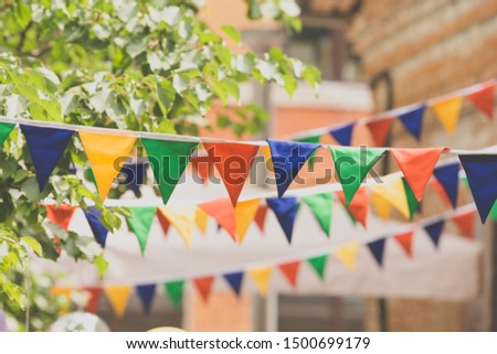 Garland decoration at the fair. Decorations of colorful pennants and colorful flag of the festival. Strings with flags.