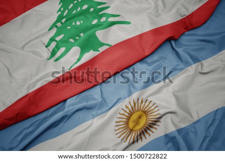 waving colorful flag of argentina and national flag of lebanon. macro