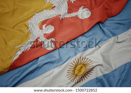 waving colorful flag of argentina and national flag of bhutan. macro