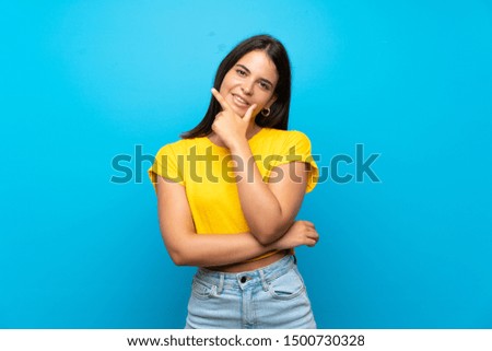 Young girl over isolated blue background smiling