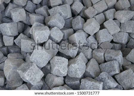 Granite stones for natural stone paving in the building materials trade for sale. Close-up
