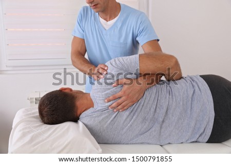 Back pain , Physiotherapy. Man Chiropractic pain relief adjustment /Kinesiology treatment . Osteopathy practitioner Royalty-Free Stock Photo #1500791855