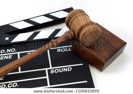 A clapboard and gavel for concepts related to movie production laws and regulations.