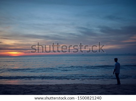 A Boy on Observing a Scenic Sunset at Batu Ferringhi Beach in Penang, Malaysia
