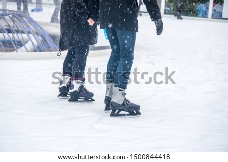 Closeup view of ice skates on outdoor ice rink for habitants. Ice skating in winter. Entertainment.