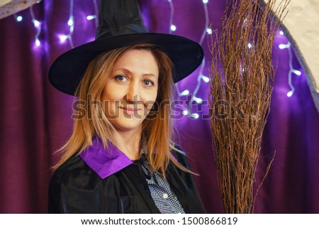 portrait of a woman in a magician's hat with a broom on a bokeh background, Halloween concept