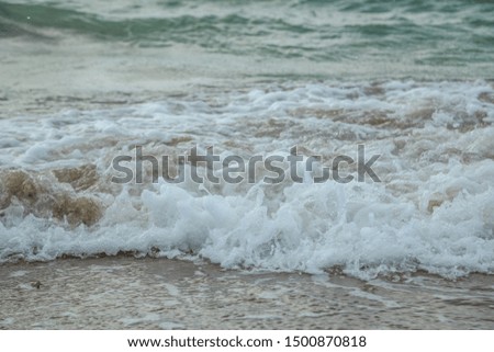 background of waves beating on a sandy beach in stormy weather