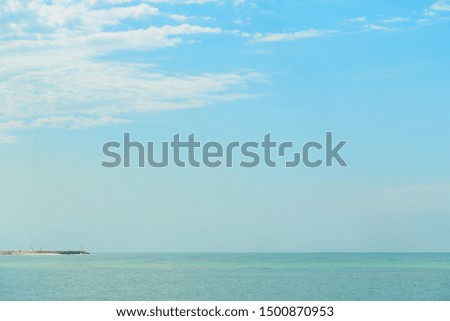 background of blue sky with beautiful clouds and a small part of the azure sea in the frame. the focus is selective.