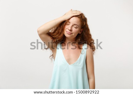 Young smiling redhead woman girl in casual light clothes posing isolated on white background studio portrait. People lifestyle concept. Mock up copy space. Putting hand on head, keeping eyes closed