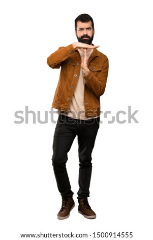 Handsome man with beard making time out gesture over isolated white background