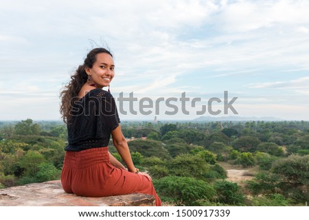 Horizontal picture of asian eyes girls sitting on the rooftop of ancient buddhist temple in Bagan, Myanmar