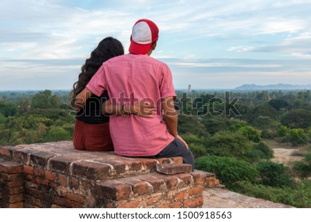 Horizontal picture of lovely couple hugging each other on the rooftop of ancient buddhist temple in Bagan, Myanmar