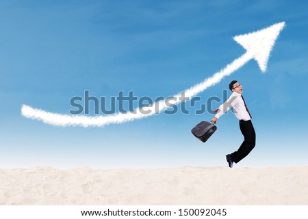 Businessman jumping under increase arrow sign 