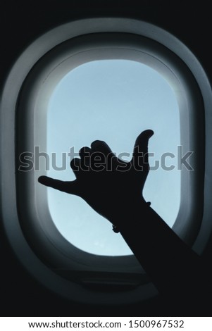 
hand silhouette in a plane window