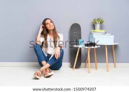Young woman sitting on the floor laughing and looking up