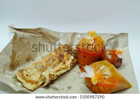 A picture of "roti sardin" or sardine prata famous in Malaysian restaurant with curry, spicy sauce and dal.
