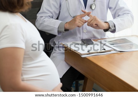 Doctor showing warning with hand sign and talking to the pregnant woman. Prohibition during pregnancy concept