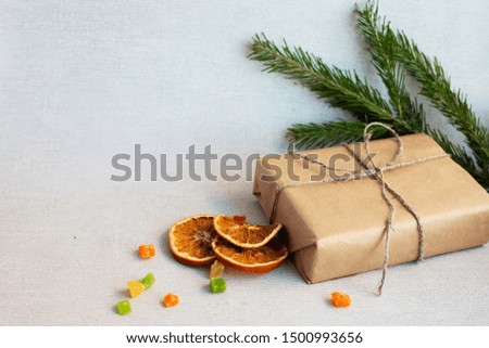 christmas composition on a light background with gift box , dryed fruit, fir branches