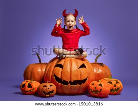 Happy Halloween! Cute little devil with pumpkins on violet background.