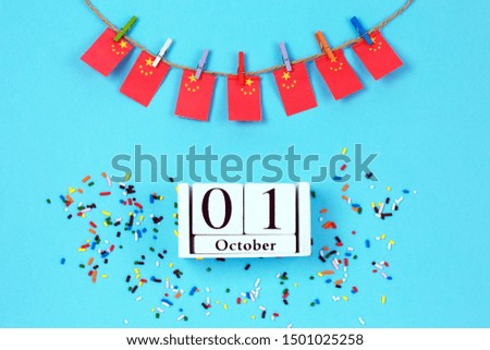 October 1 Wooden calendar, confetti and flag on blue background. Concept independence day of China and China national day.