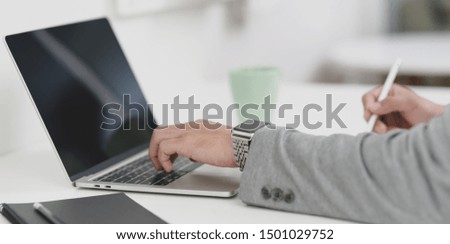Close-up view of young professional businessman planing the strategy for his project with laptop computer 