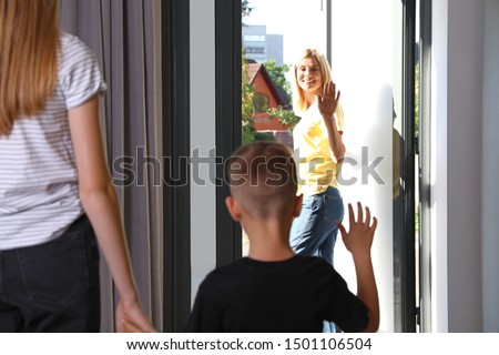 Mother leaving her little son with teen nanny at home Royalty-Free Stock Photo #1501106504