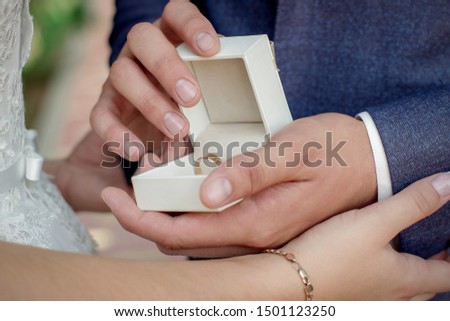 Will you be my woman wife? 
Wedding ring in a special box, holds in the hands of the groom. Man in a suit shows a ring. The groom has a beautiful casket with wedding rings in her hands. Wedding.
