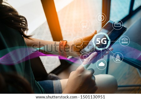 Close up of female hand holding a phone with a 5G hologram in coffee shop. 5G network wireless systems.The concept of 5G network, high-speed mobile Internet, new generation networks. Royalty-Free Stock Photo #1501130951