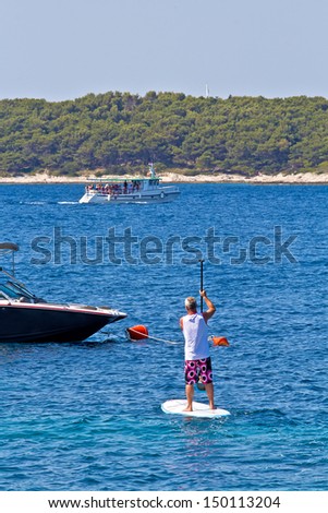 Rower practicing in the sea. Sunny weather, health, sports. Hvar. Croatia. High quality stock photo.