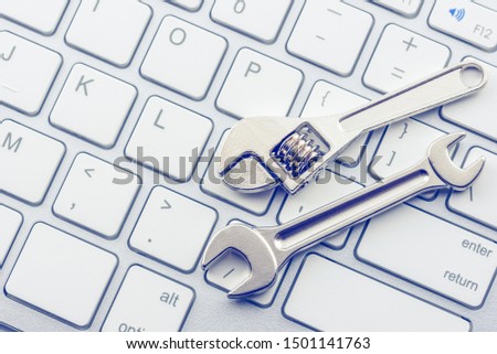 Computer hardware service and maintenance concept : Open-end wrench or spanner on a keyboard, depicts repairing / software setting and updating or changing to a newer version to improve performance Royalty-Free Stock Photo #1501141763
