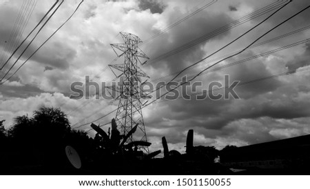 A Silhouette picture of electricity pillar in the dark cloud before raining. Silhouette picture. A cloudy environment picture. 