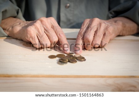 Hands of an elderly man holding coins. The concept of lack of money, the poor, the small pension of old people. Image. Royalty-Free Stock Photo #1501164863