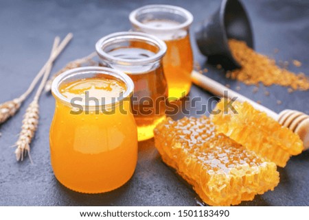 Jars of sweet honey and combs on table