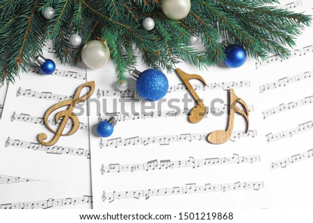 Flat lay composition with Christmas decorations and wooden music notes on sheets