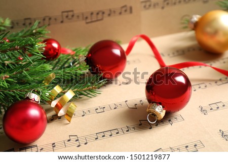 Composition with Christmas decorations on music sheets, closeup