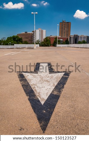 Arrow in parking lot and view of highrises from a parking garage in Towson, Maryland.