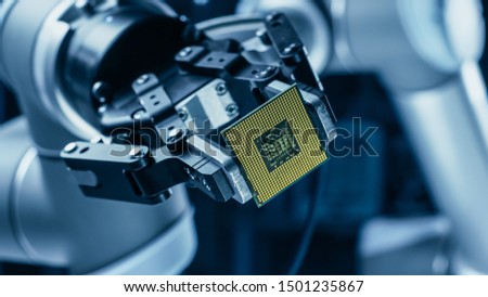 Modern High Tech Authentic Robot Arm Holding Contemporary Super Computer Processor. Industrial Robotic Manipulator End Effector Holding CPU Chip Royalty-Free Stock Photo #1501235867