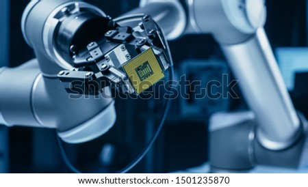 Modern High Tech Authentic Robot Arm Holding Contemporary Super Computer Processor. Industrial Robotic Manipulator End Effector Holding CPU Chip Royalty-Free Stock Photo #1501235870