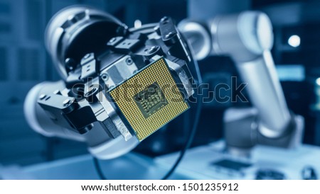 Modern High Tech Authentic Robot Arm Holding Contemporary Super Computer Processor. Industrial Robotic Manipulator End Effector Holding CPU Chip Royalty-Free Stock Photo #1501235912