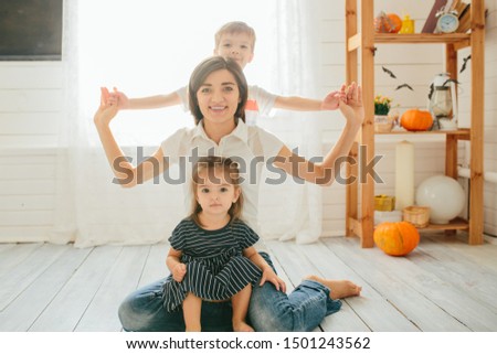 Mother with kids glazing cookies for Halloween celebration Happy Halloween concept