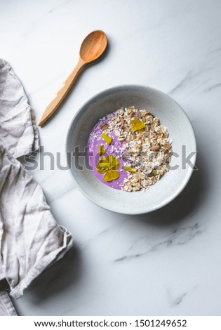 healthy breakfast, a bowl with organic granola, chocolate pieces and vegan soya yogurt on marble background with copy space