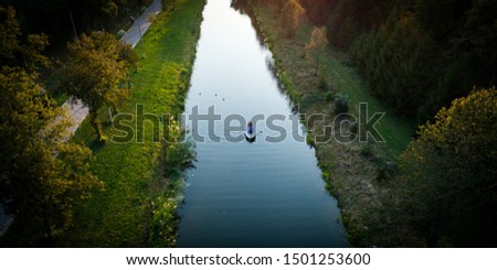 Aerial View. Couple in love ride a rowing boat on the river during sunset. 