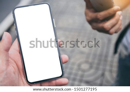 Mockup image blank white screen cell phone.men hand holding texting using mobile at outdoor in  the city. background empty space for advertise text. contact business,people communication,technology 