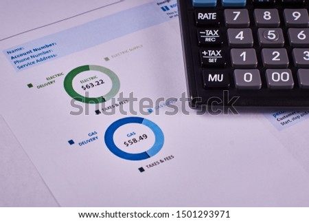 Communal payments. Pie charts gas and electric supply record in the utility bill next to calculator. Close-up Royalty-Free Stock Photo #1501293971