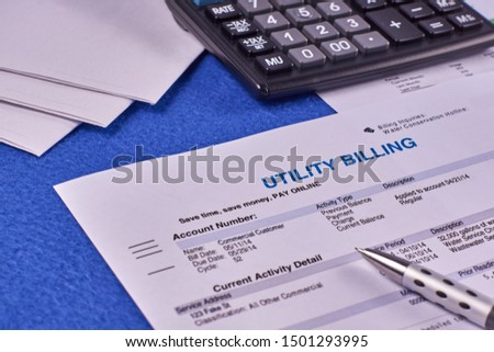 Communal payments. Utility billing sheet, calculator, pen and envelopes on a blue velvet background Royalty-Free Stock Photo #1501293995