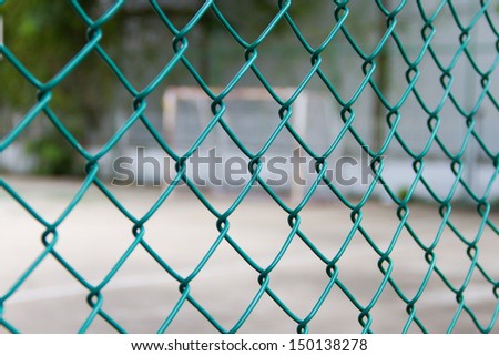 Wire fence with futsal field on background Royalty-Free Stock Photo #150138278