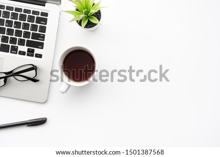 White office desk table with laptop computer, cup of coffee and office supplies. Top view with copy space, flat lay.