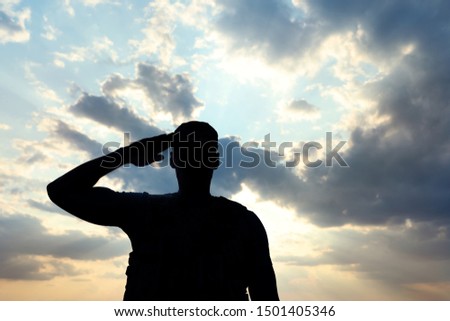 Soldier in uniform saluting outdoors. Military service